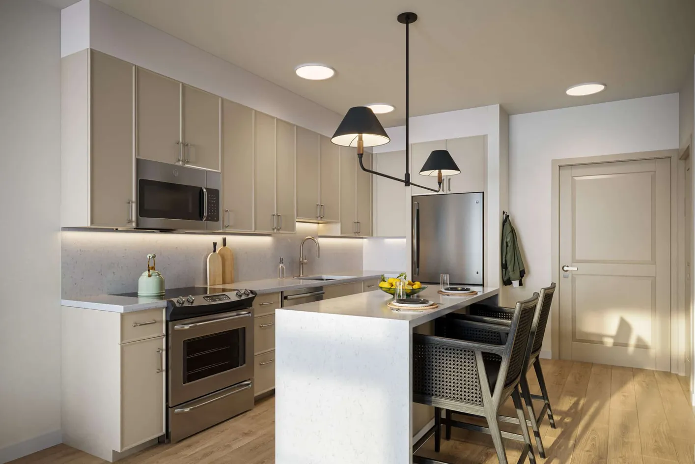 Modern apartment kitchen with quartz countertops and stainless steel appliances.