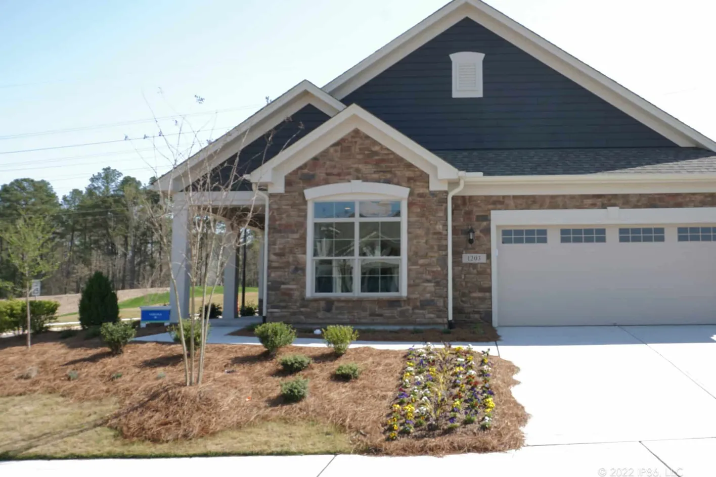 Verona model exterior with stone accents, dark siding, and a two-car garage
