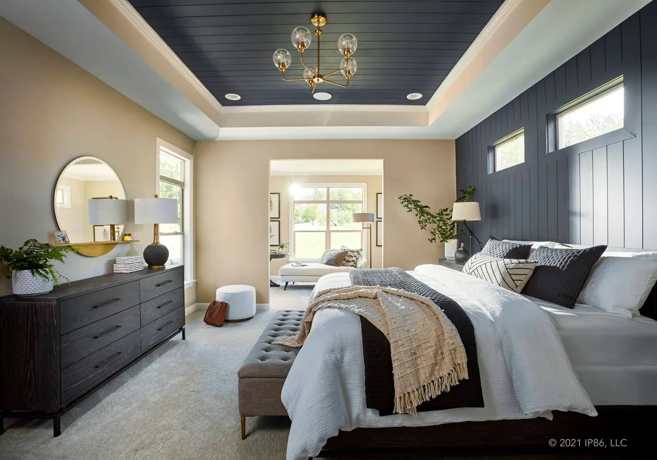Spacious primary suite featuring a tray ceiling and elegant finishes