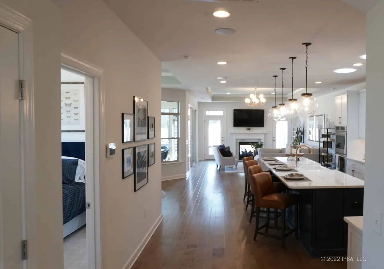 Open living space with kitchen island, dining area, and living room with fireplace