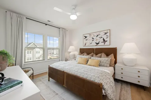 Primary bedroom with large windows and neutral decor