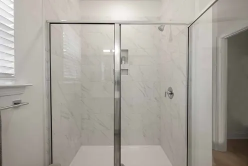 Glass-enclosed shower with tile surround