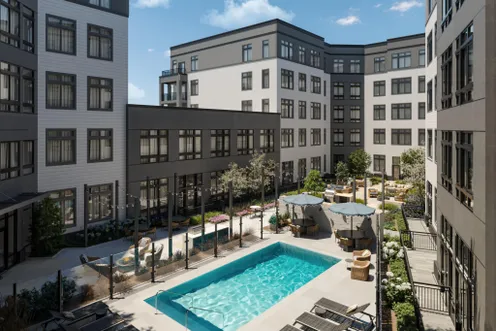 Resort-style outdoor pool with lounge seating and landscaped courtyard views.
