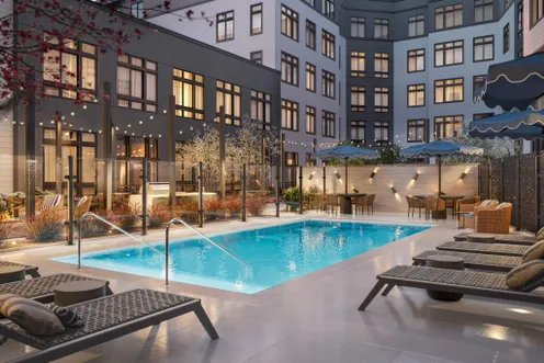 Evening view of the resort-style pool and outdoor seating areas.