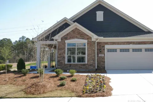 Verona model exterior with stone accents, dark siding, and a two-car garage