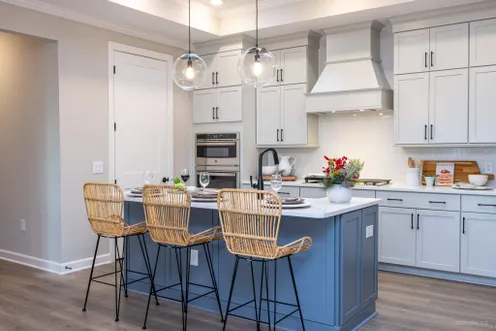 Stylish kitchen with large island and woven barstools